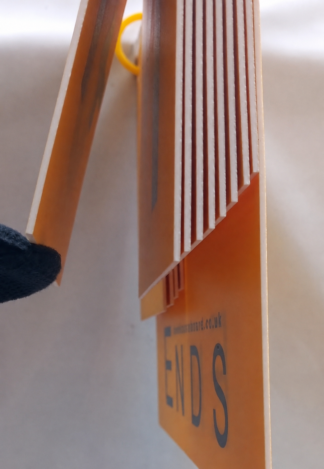 A gloved fingertip hooked into the smooth rounded ring of a number, lifting it clear of the others